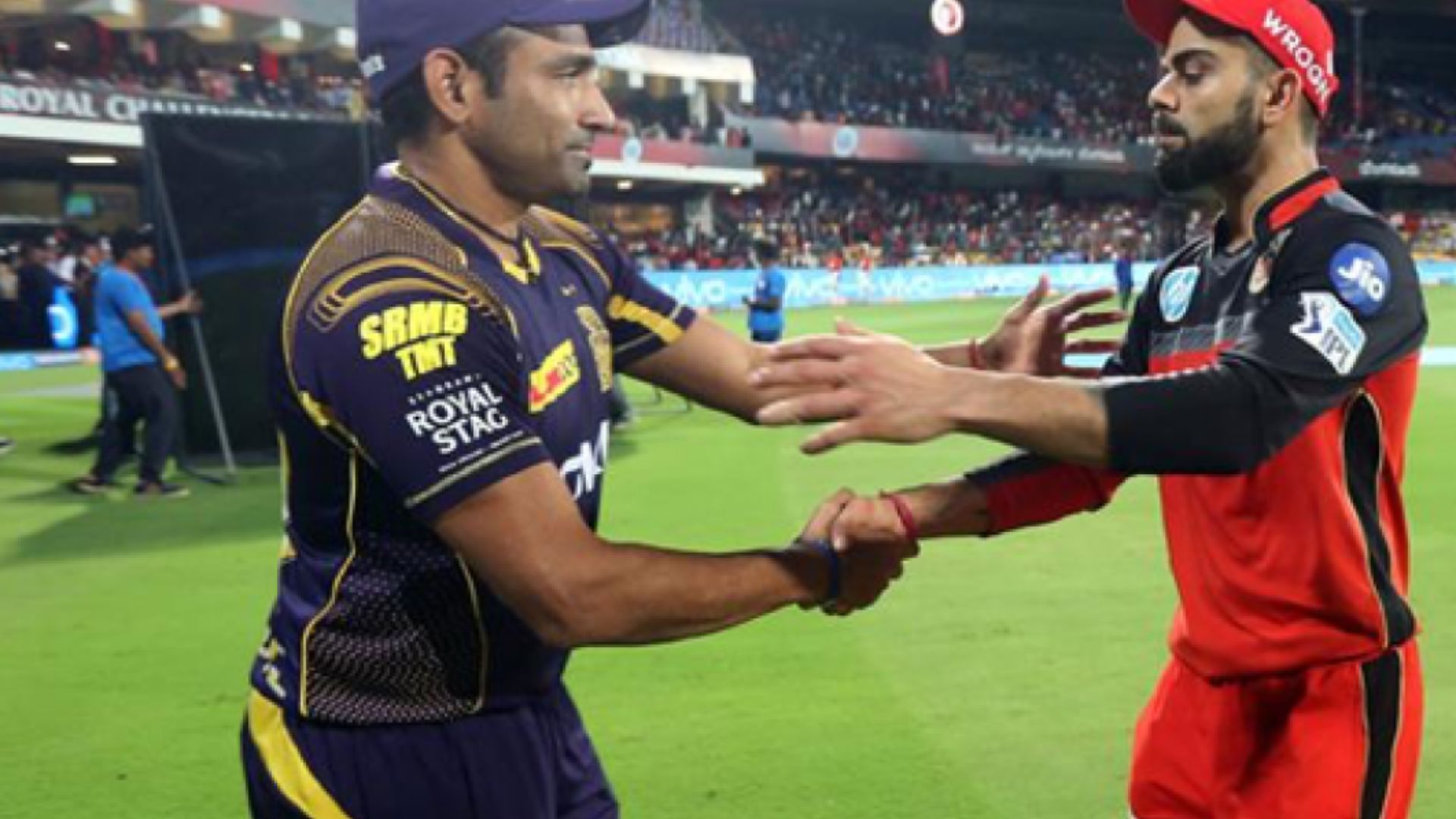 Kohli shake hands with Uthappa during an IPL game. 