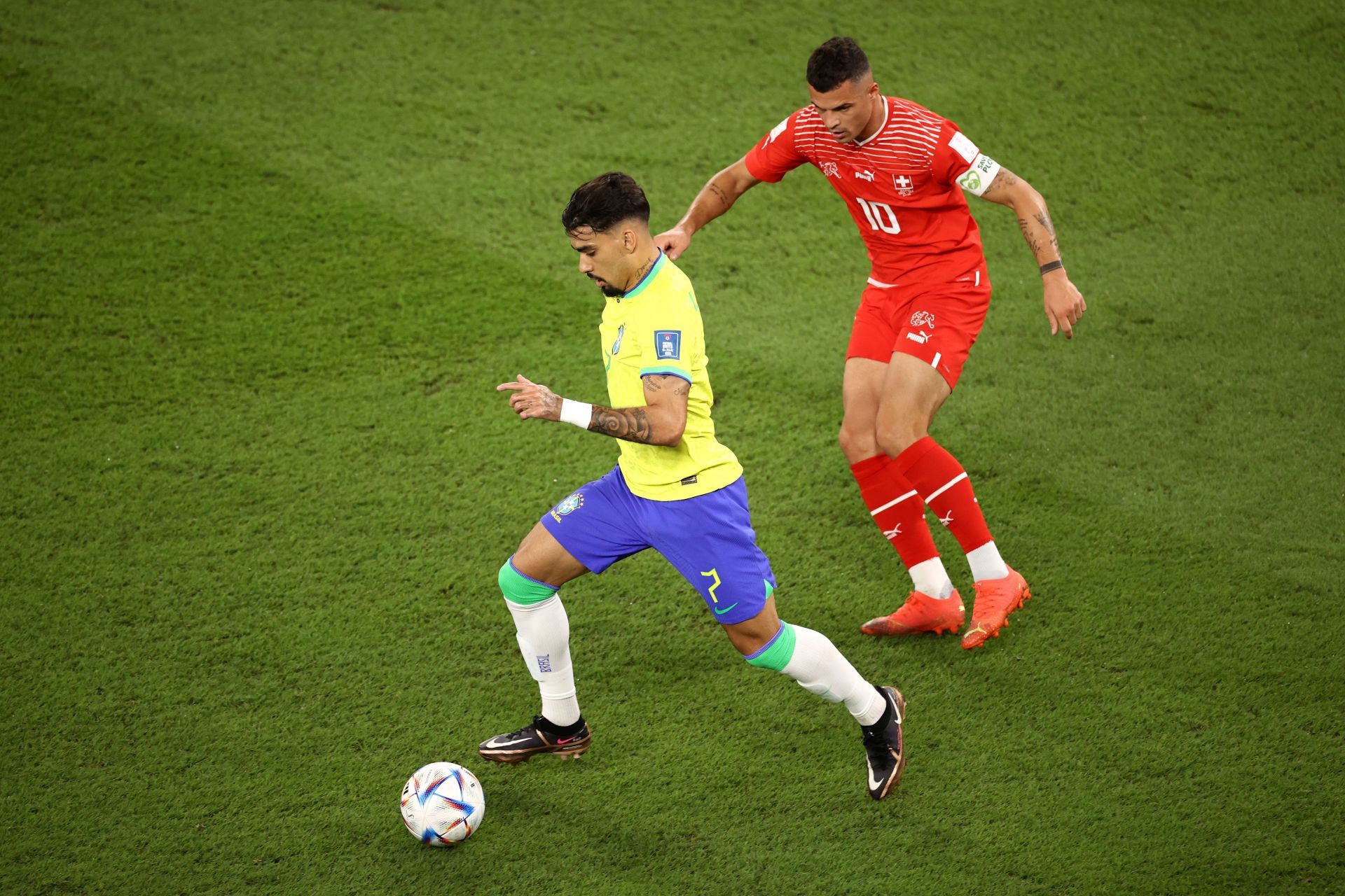 Lucas Paqueta controls the ball under pressure from Granit Xhaka.