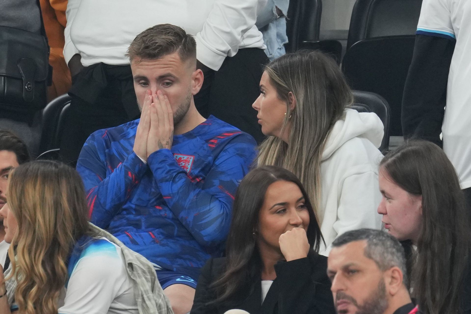 Luke Shaw looking sad, while his partner Anouska Santos talks with him. (Source: The Sun)