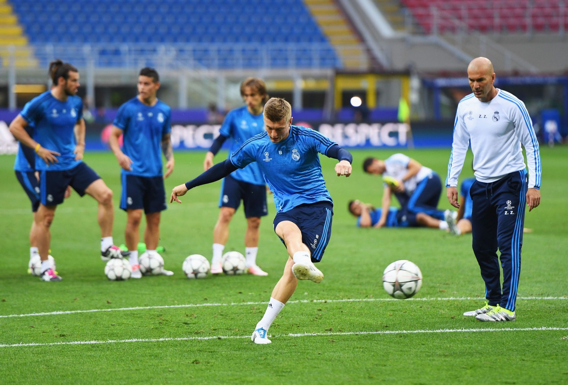 Toni Kroos takes a shot on goal as Zinedine Zidane looks on during a Real Madrid training session in 2016.