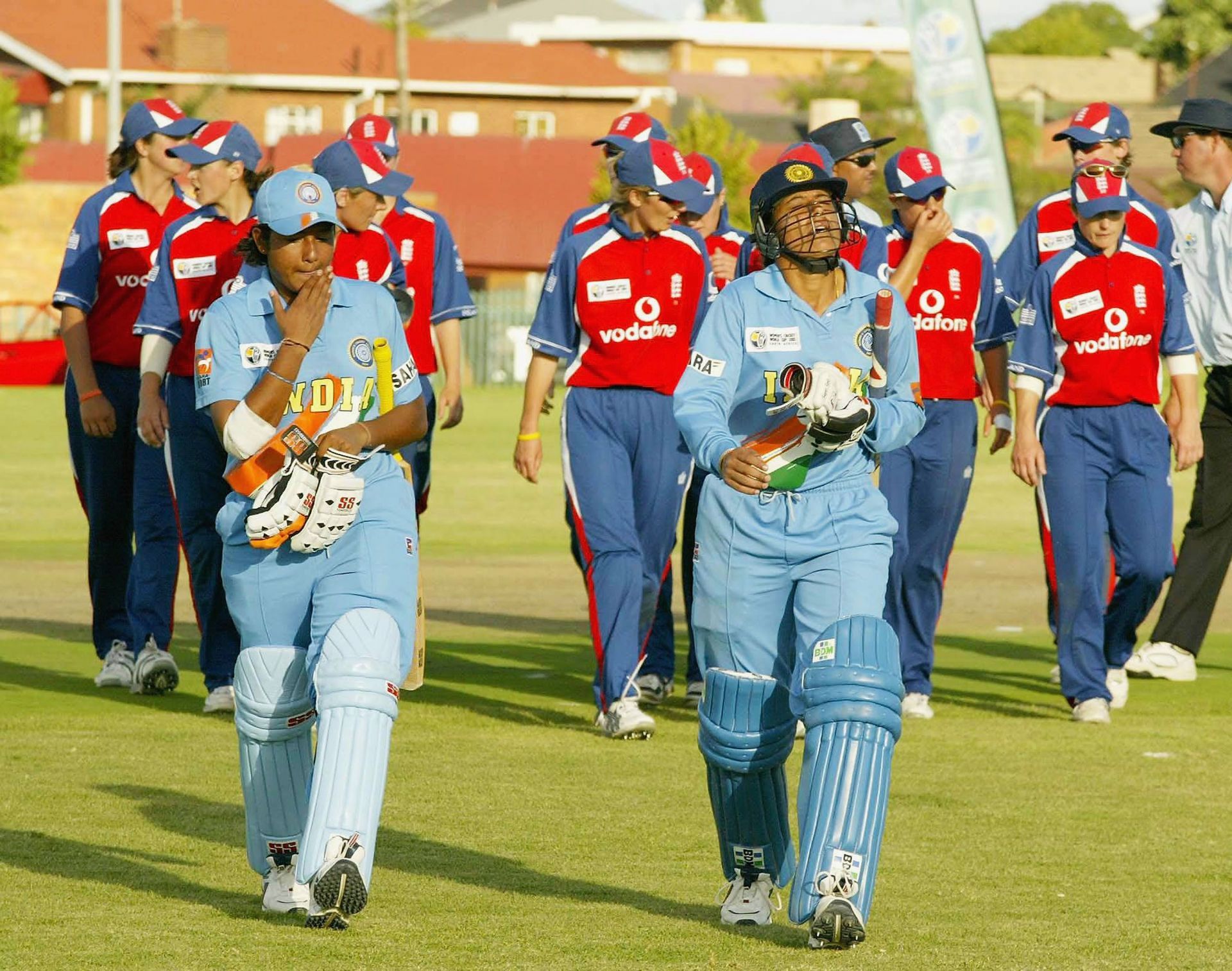 Anjum Chopra and Rumeli Dhar of India lead England off the field during the England v India Women's World Cup match on March 28, 2005, at Laudium Cricket Oval in Pretoria, South Africa. (Photo by: Getty)