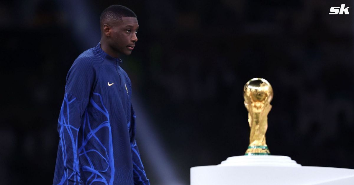 A dejected Kolo Muani walks past the World Cup trophy