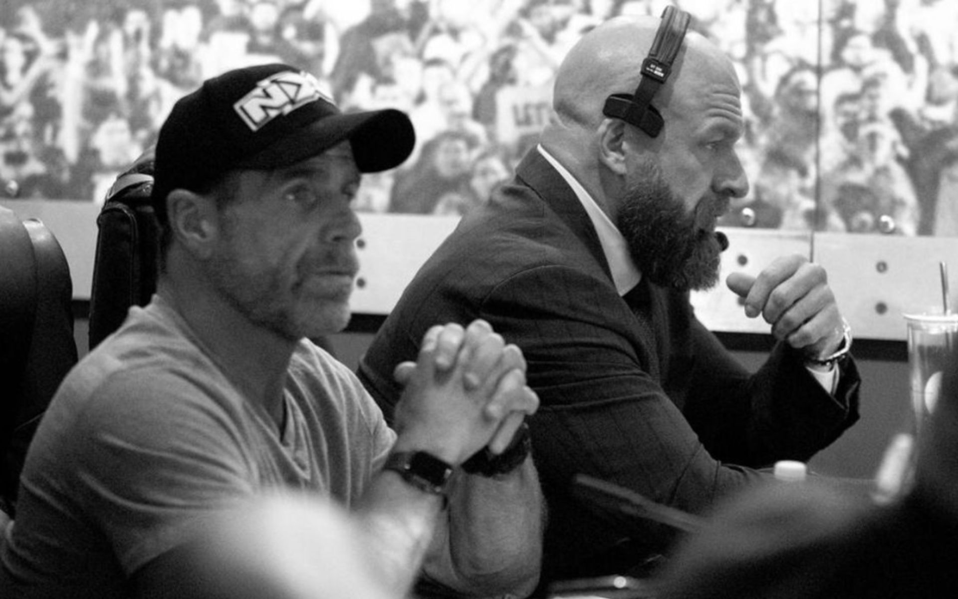 Shawn Michaels and Triple H overlooking an NXT event backstage