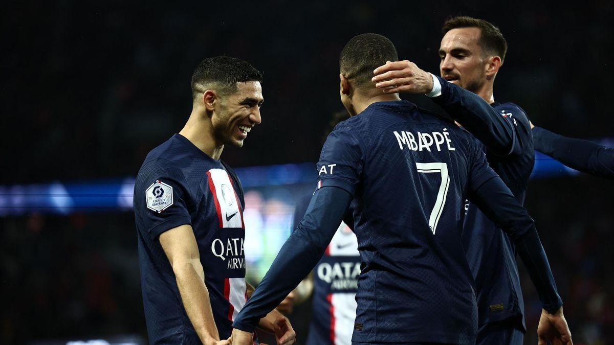 PSG players celebrate after scoring against RC Lens in Ligue 1.