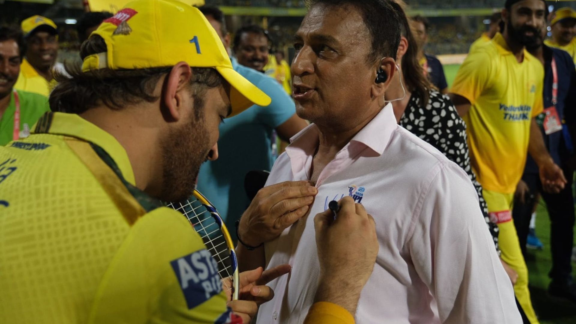 MS Dhoni (L) signing an autograph on Sunil Gavaskar