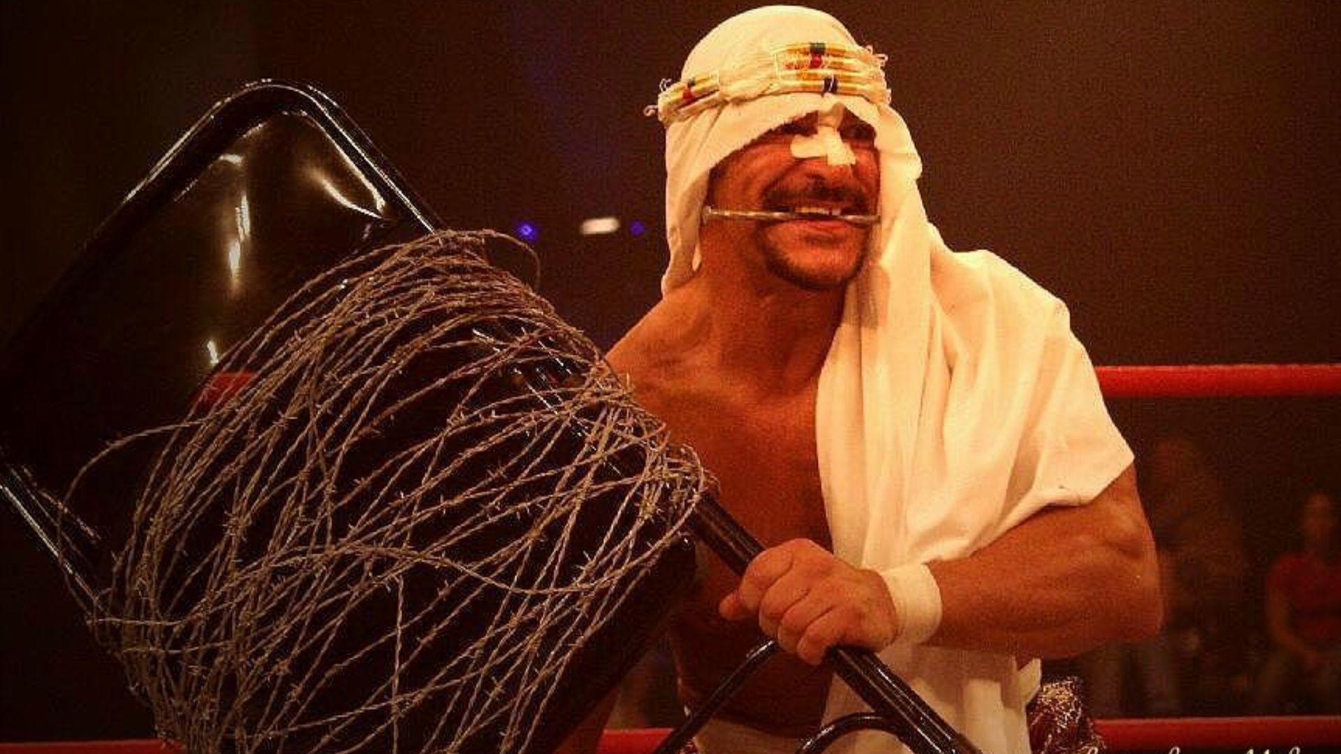 Sabu wields his signature barbed wire steel chair at an indie wrestling event.