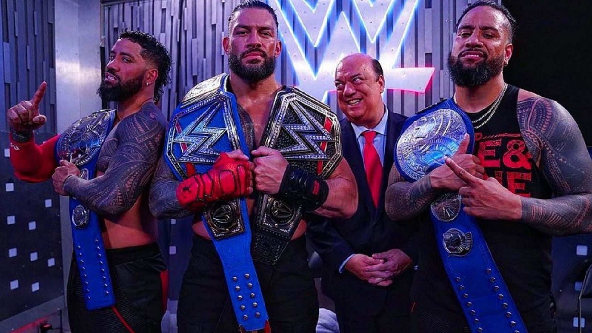 The Usos and Roman Reigns pose with their championship gold.