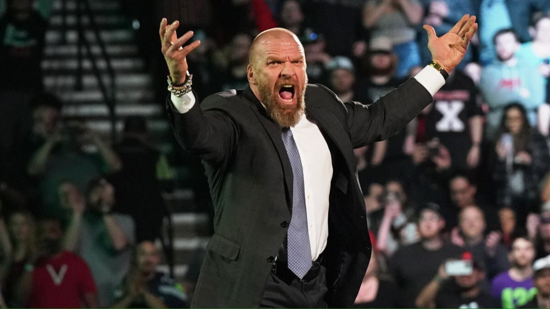 Triple H hypes up the crowd at a WWE event.