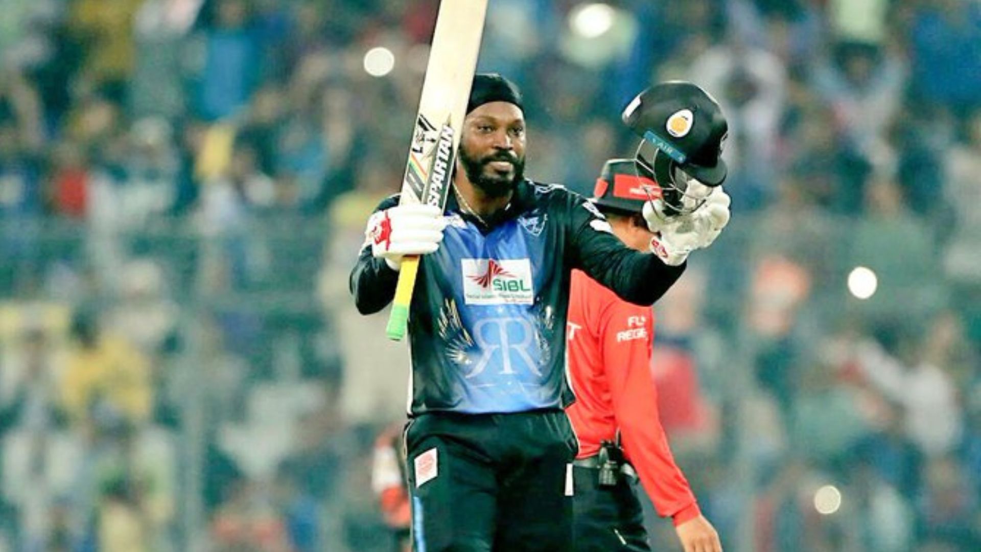 Chris Gayle raises his bat after scoring a century in the 2017 BPL final