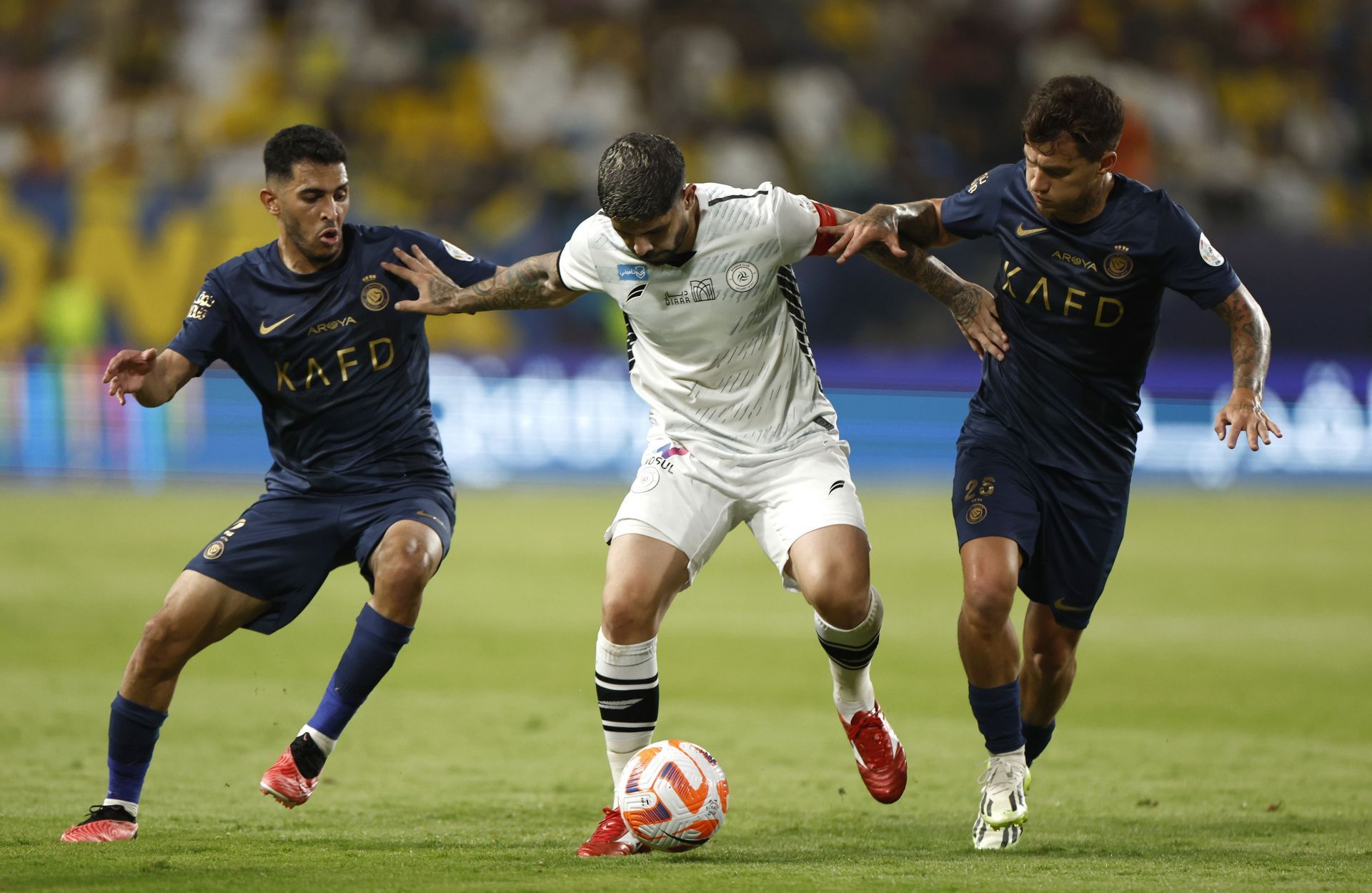 Ever Banega of Al-Shabab battles for the ball with Sultan Al Ghannam (left) and Otavio (right) of Al-Nassr