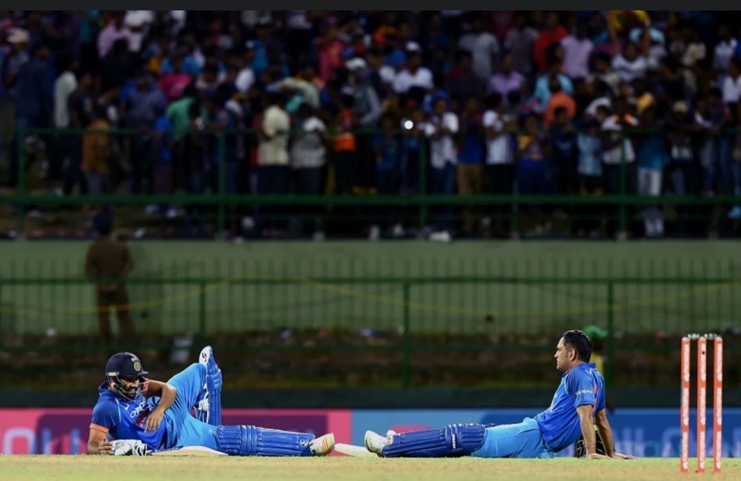 Rohit Sharma and MS Dhoni lying down at the Pallekele International Cricket Stadium [Getty Images]