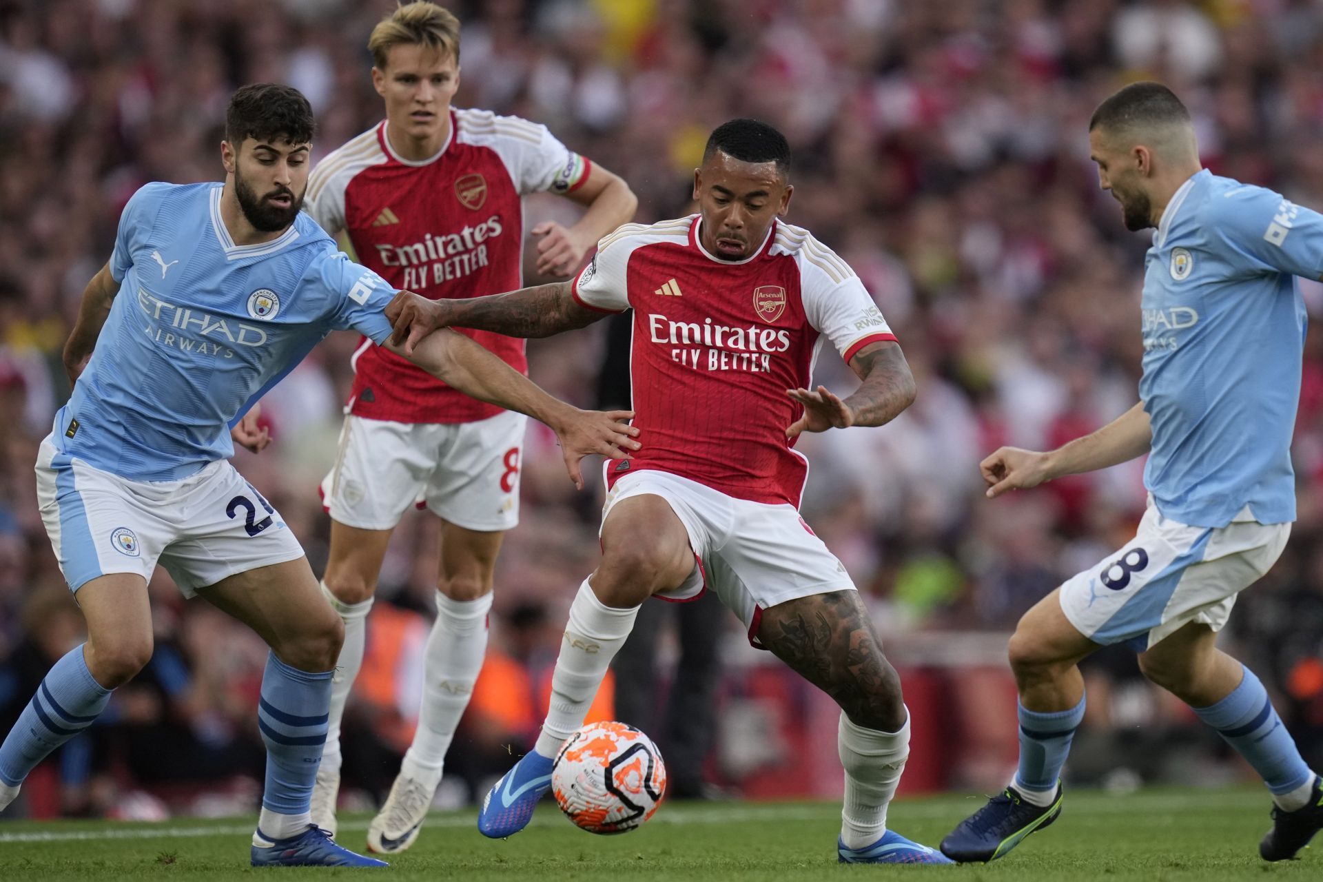 Arsenal and Manchester City players contesting for the ball.