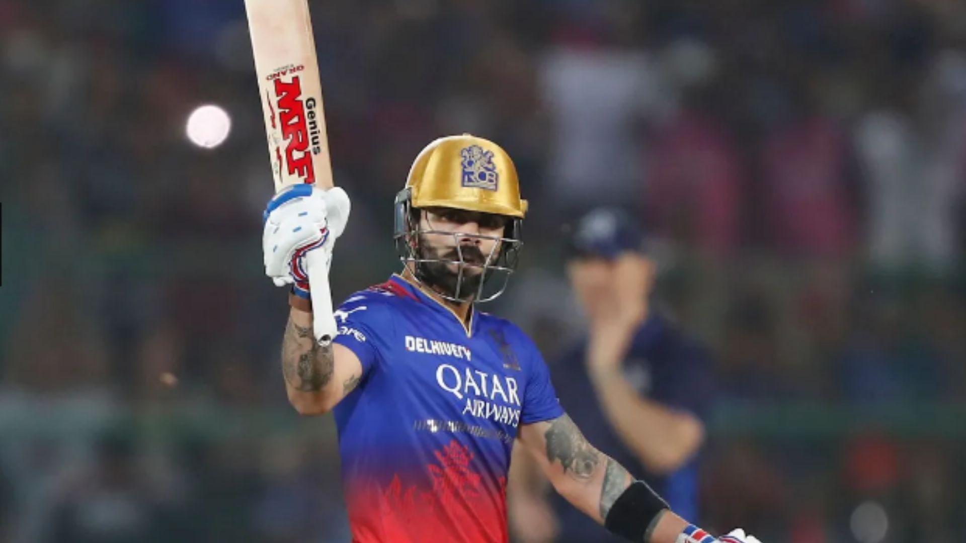 Virat Kohli raises his bat after scoring his 8th IPL century. 