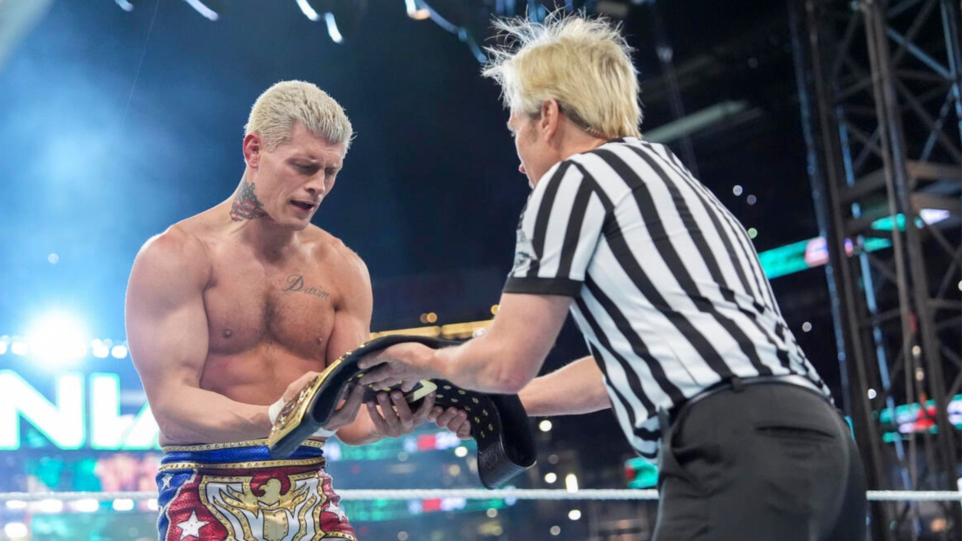 Referee Charles Robinson (right) handing Rhodes the title at WrestleMania.