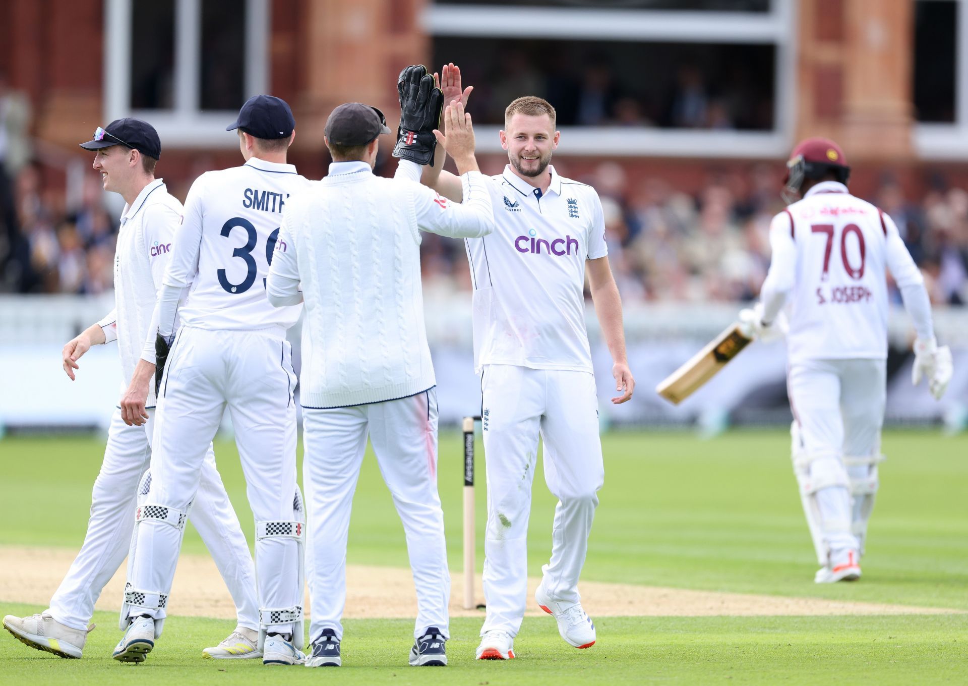 Atkinson celebrates with teammates after picking the wicket of Shamar Joseph