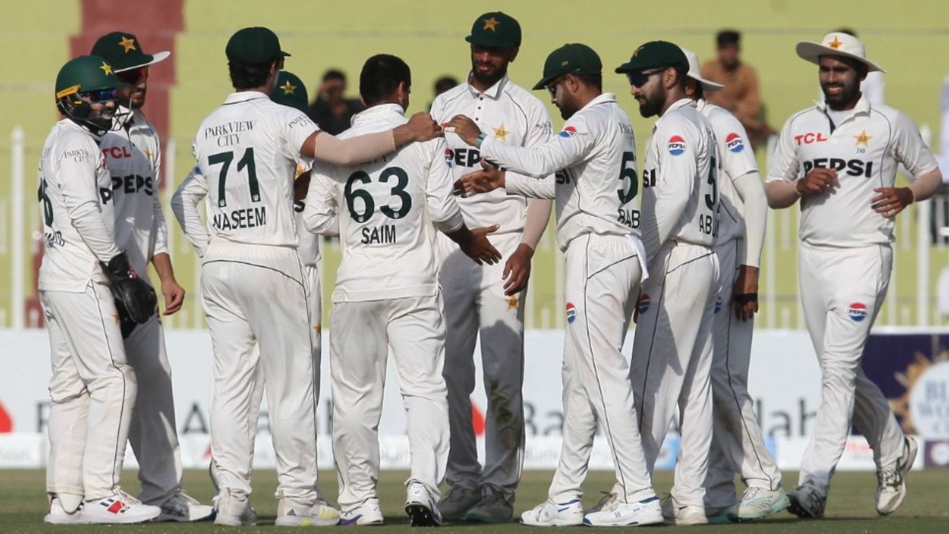 Teammates gather around to celebrate Saim Ayub&#039;s first Test wicket (Image credits: @TheRealPCB on X)