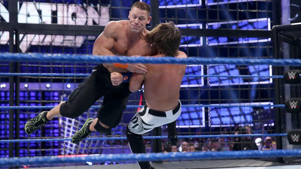 John Cena shoulder-tackles AJ Styles in the 2017 Elimination Chamber match [Image from WWE.com]