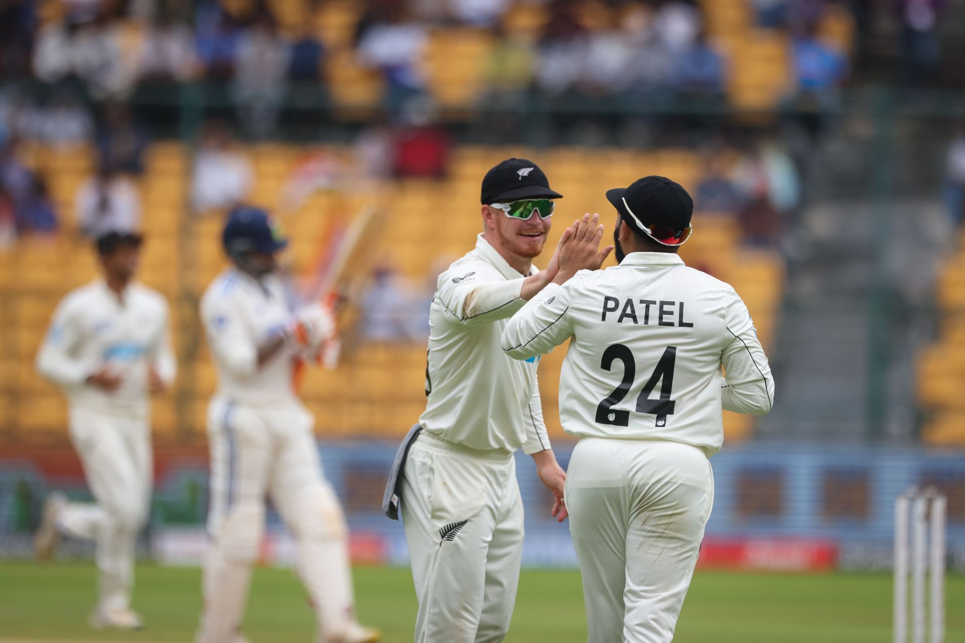 Glenn Phillips and Ajaz Patel of New Zealand celebrate the wicket of Ravindra Jadeja of India during day two of the First Test match between India and New Zealand at M. Chinnaswamy Stadium on October 17, 2024, in Bengaluru, India.