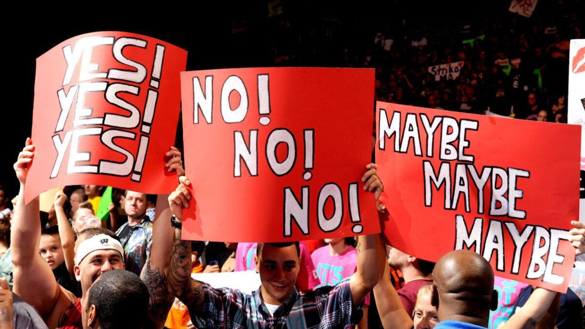 Fans hold a sign at a WWE event (Image via WWE.com)