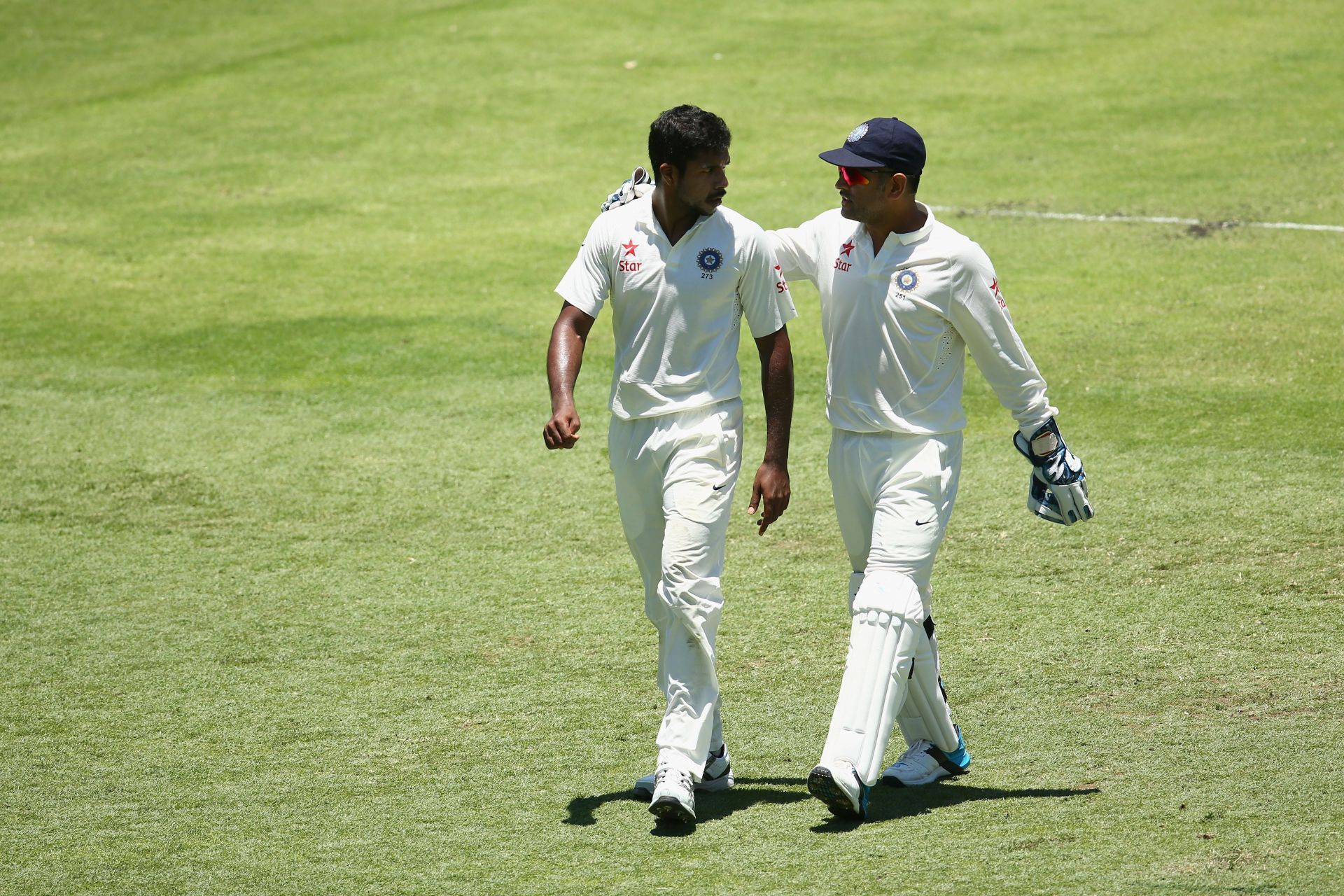 MS Dhoni puts an arm around his Jharkand and India teammate Varun Aaron - Source: Getty