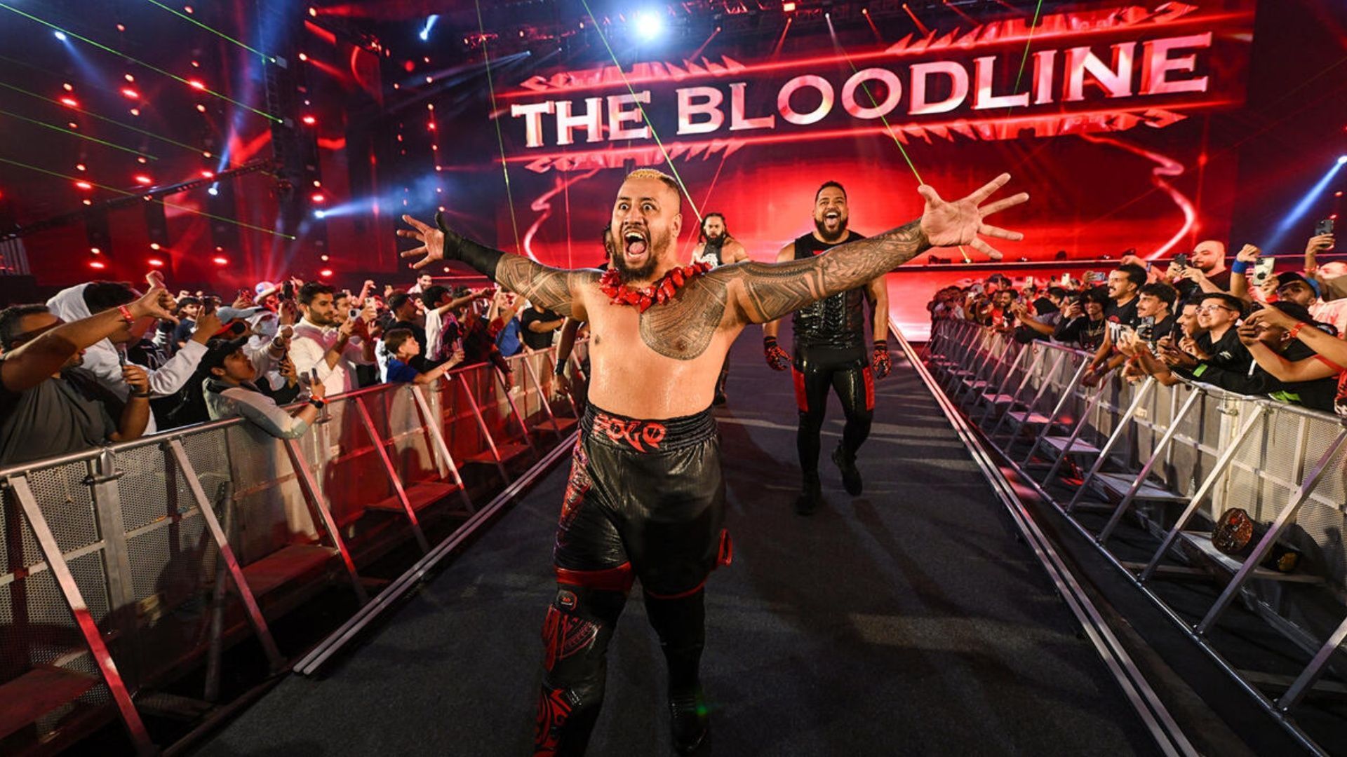 Solo Sikoa makes his entrance with his Bloodline members at a WWE event (Images via WWE.com)