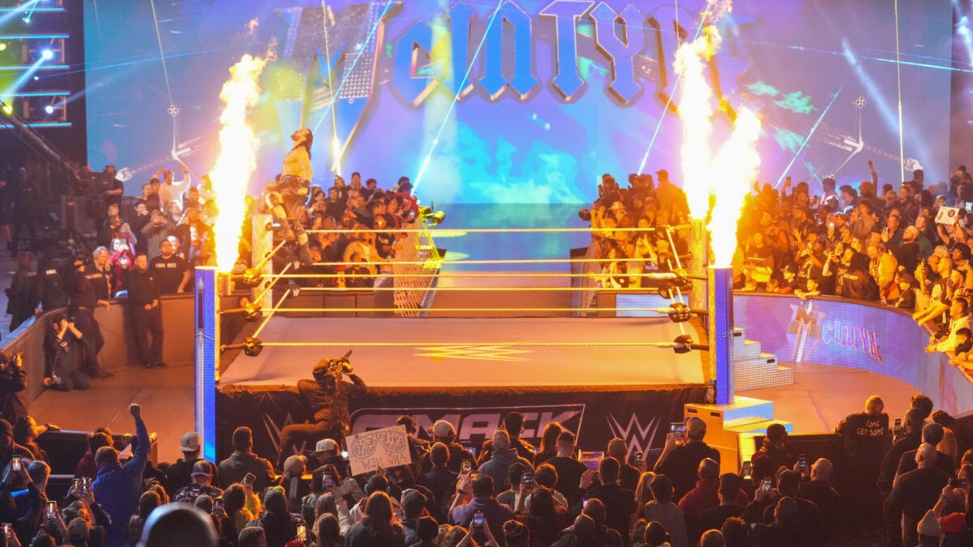 A wide-angle shot of Drew McIntyre posing during his entrance (Image via WWE.com).