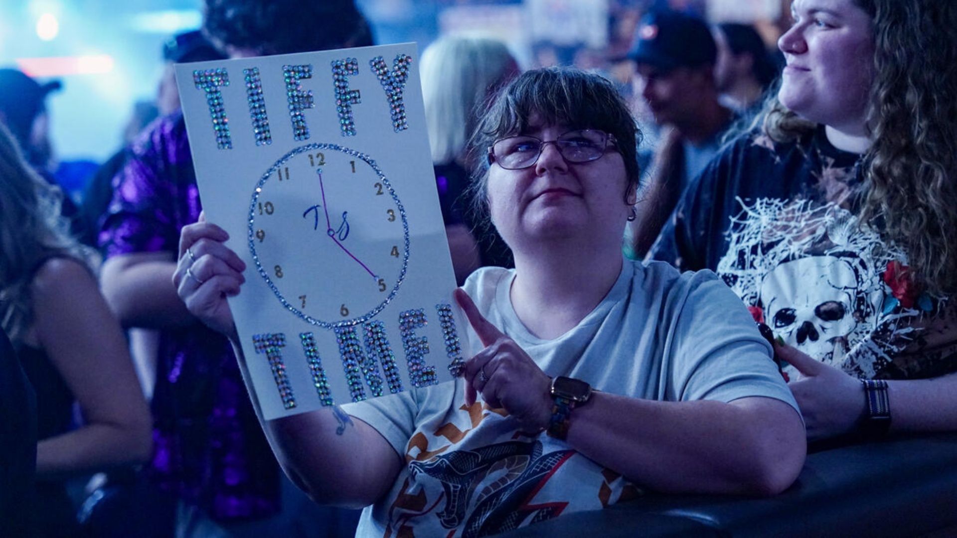 A fan holding a sign at a WWE event (Image via WWE.com).