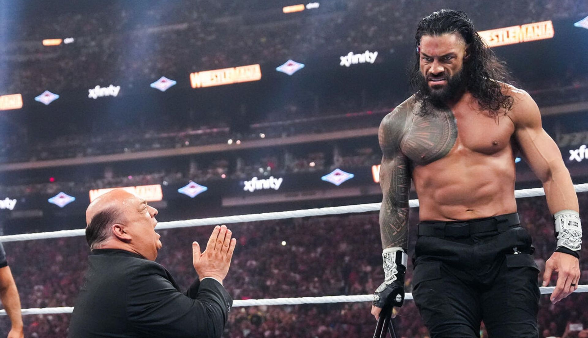 गुस्से में दिखाई दे रहे रोमन रेंस से माफी मांगते पॉल हेमन (Photo: WWE.com)