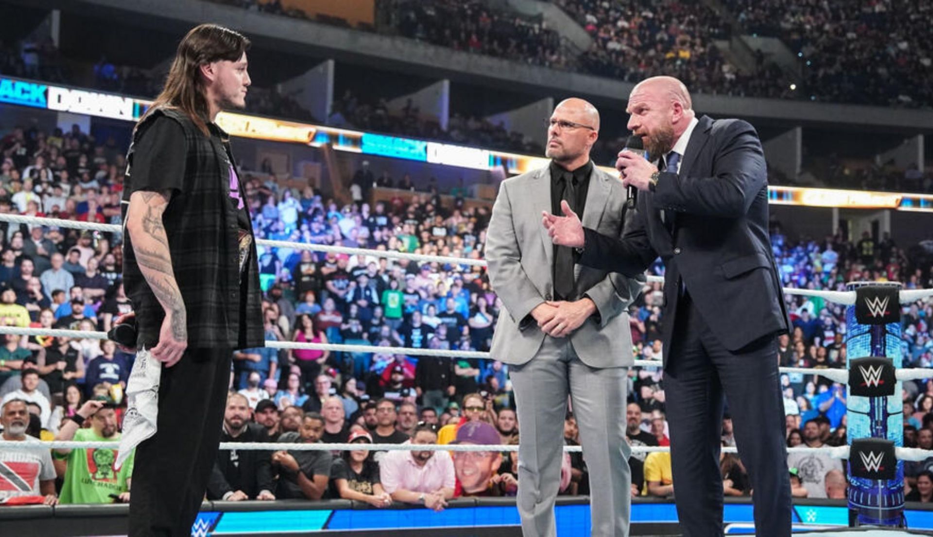 ट्रिपल एच, एडम पीयर्स को डॉमिनिक मिस्टीरियो के बारे में कुछ बताते हुए (Photo: WWE.com)