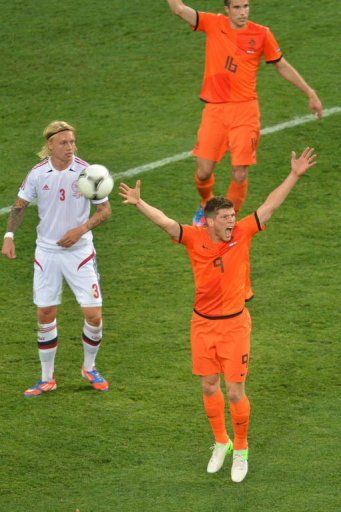 Dutch forward Klaas-Jan Huntelaar (R) gestures next to Danish defender Simon Kj&Atilde;&brvbar;r