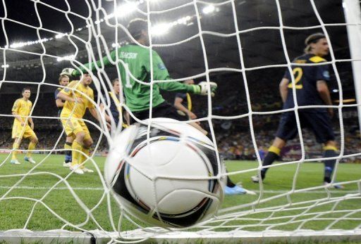 Ukrainian forward Andrei Shevchenko scores past Swedish goalkeeper Andreas Isaksson