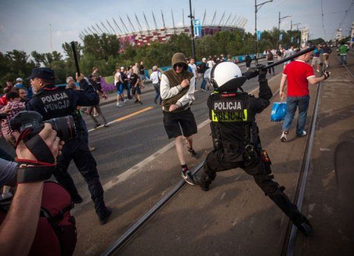 Polish riot police react after Polish and Russian football fans clash in Warsaw on June 12