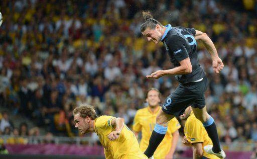 English forward Andy Carroll heads the ball to score