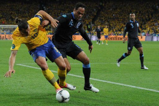 English defender Joleon Lescott (C) clashes with Swedish forward Zlatan Ibrahimovic