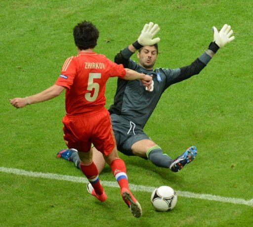 Greek goalkeeper Michalis Sifakis stops a shot by Russian defender Yuri Zhirkov