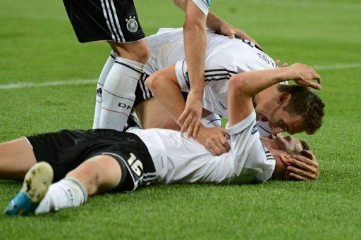 German midfielder Lars Bender (down) is congratulated by teammates after scoring