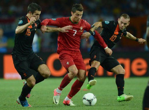 Portuguese forward Cristiano Ronaldo vies with Dutch midfielder Wesley Sneijder (R) and Dutch forward Robin van Persie