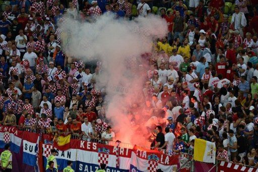 Fans of Croatia&#039;s national football team react next to a flare