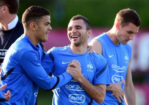 French midfielder Hatem Ben Arfa (L) jokes with French midfielder Marvin Martin during a training session