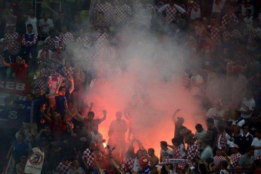 Fans of Croatia&#039;s national football team react as smoke billows from a flare at the match against Spain