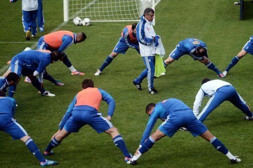 Greece&#039;s coach Fernando Santos walks as his players stretch during a training session