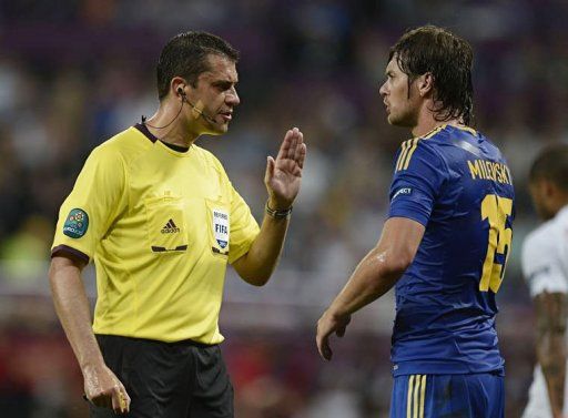 Hungarian referee Viktor Kassai gestures to Ukrainian forward Artem Milevskiy during the match