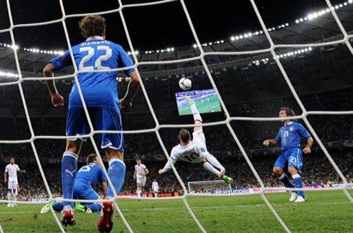 English forward Wayne Rooney (C) performs a bicycle kick during the quarter-final match England vs Italy