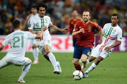 Spanish midfielder Andres Iniesta (C) runs with the ball