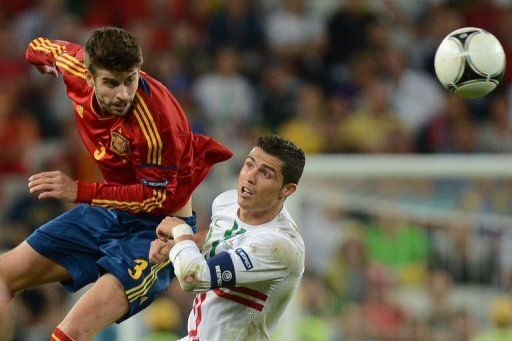 Portuguese forward Cristiano Ronaldo (R) vies with Spanish defender Gerard Pique