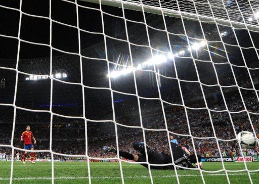 Spanish midfielder Cesc Fabregas (L) scores past Portuguese goalkeeper Rui Patricio during the penalty shoot out