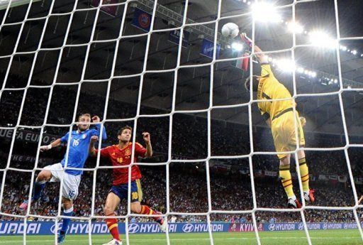 Spanish goalkeeper Iker Casillas (R) smashes the ball