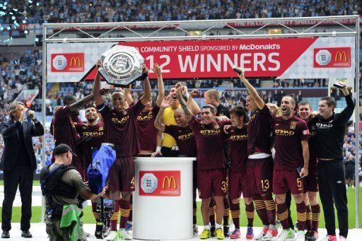 Manchester City&#039;s Vincent Kompany lifts their FA Community Shield trophy