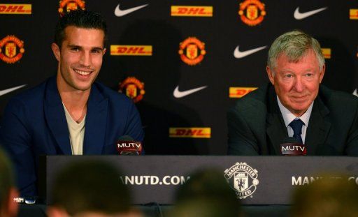 Robin Van Persie (left) attends a press conference with Alex Ferguson at Old Trafford in Manchester