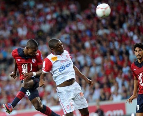 Lille's Salomon Kalou (L) heads the ball to score a goal